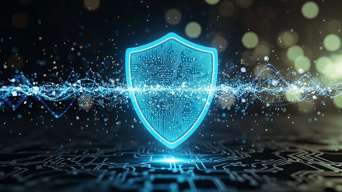 Glowing teal shield with circuit pattern over digital waveform and circuit board, symbolizing cybersecurity and data protection.