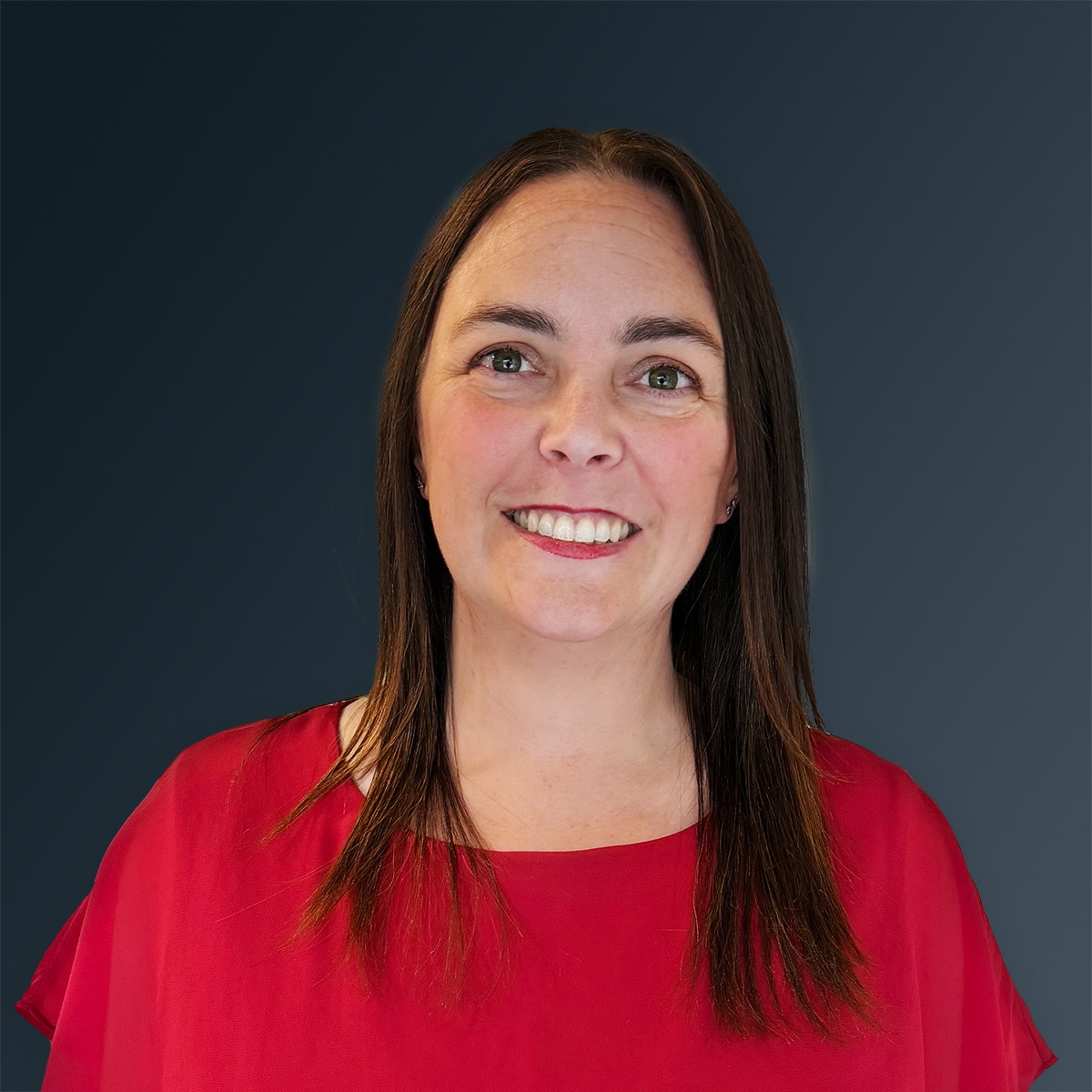Woman smiling in a red blouse with long brown hair against a dark gradient background.