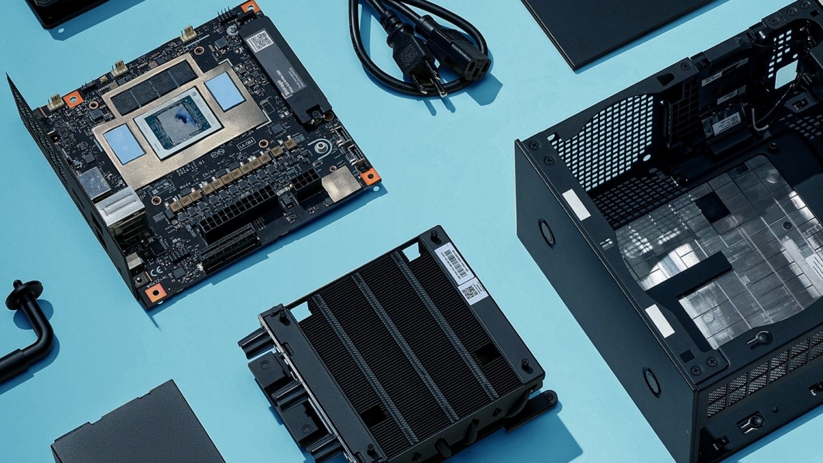 AI accelerator board, heatsink, server chassis, power cables, and computer components arranged on a blue work surface for hardware assembly.