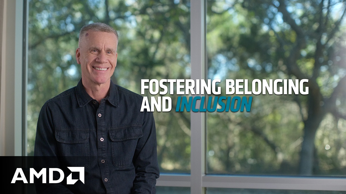 Smiling person seated indoors near large windows with the on-image text "FOSTERING BELONGING AND INCLUSION."