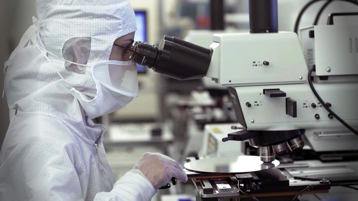 ST employee checking chips with a microscope inside a STMicroelectronics fab