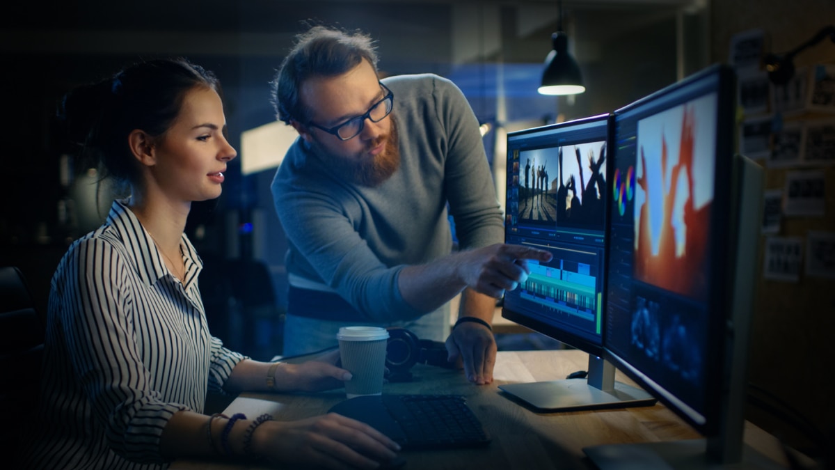 man and woman looking at computer monitor