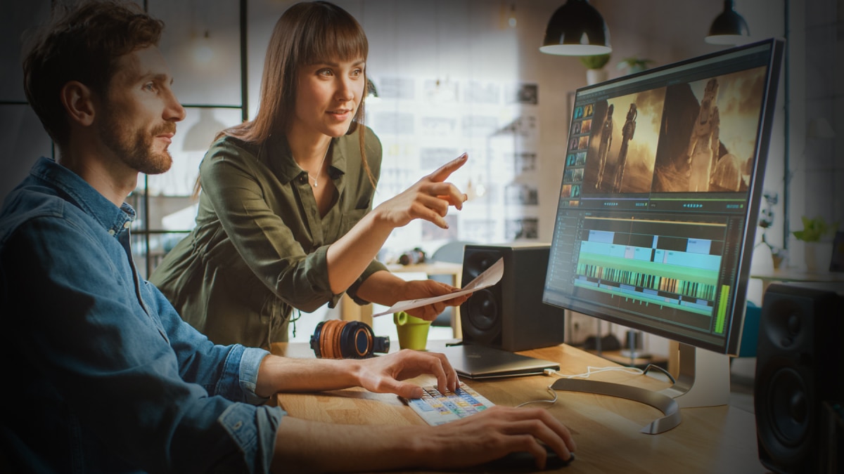 man and woman looking at computer monitor