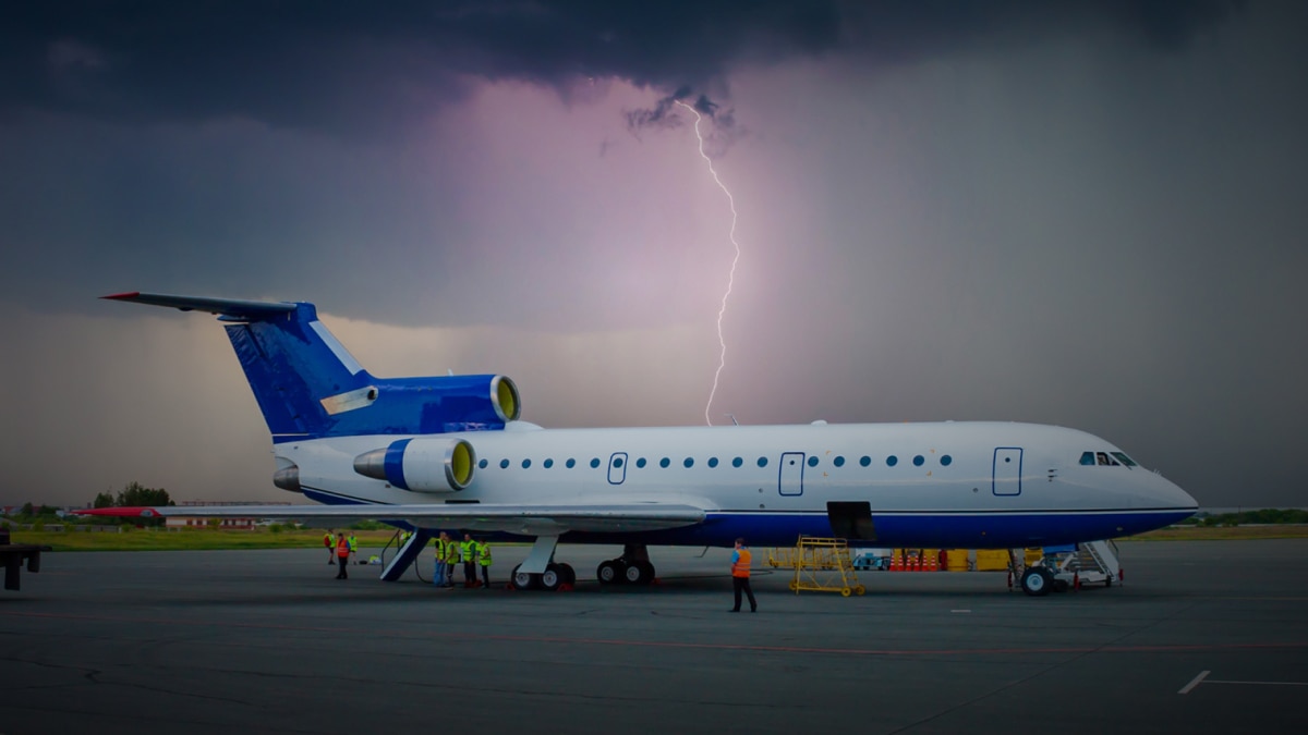Jet in front of a lightning storm on a tarmac