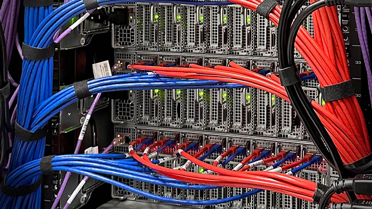 Server rack with bundled red and blue network cables connected to multiple servers and switches.