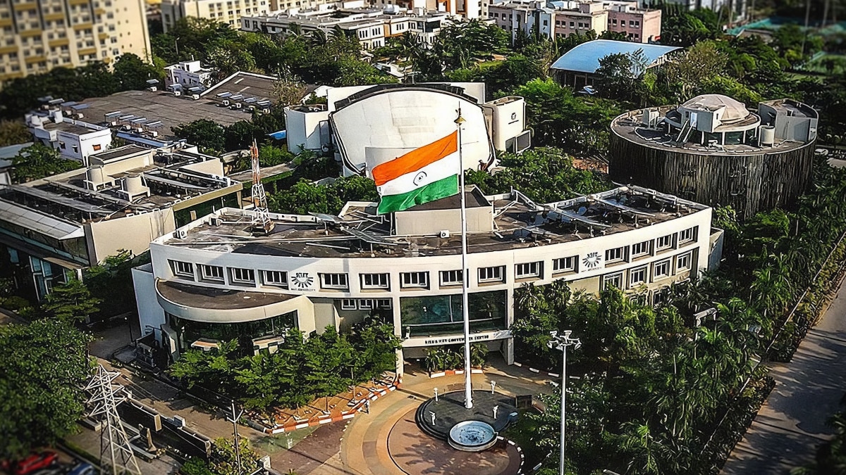 Aerial view of the KIIT campus featuring a large Indian flag, academic buildings, and landscaped grounds.