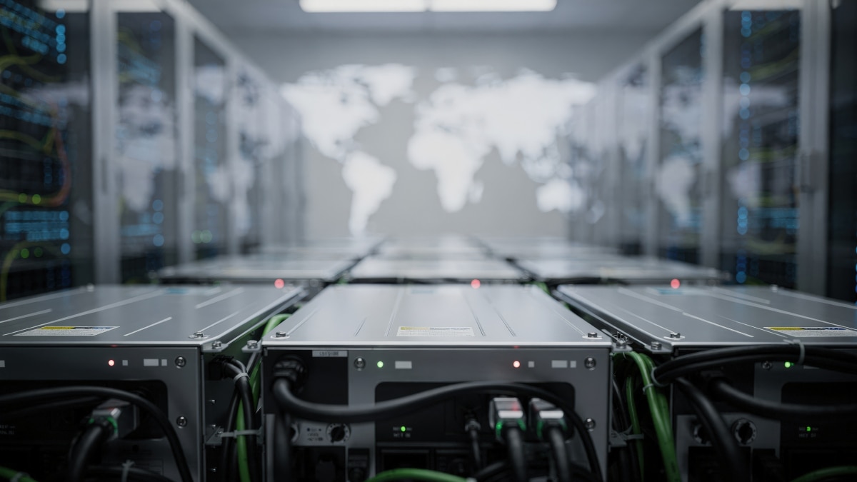 Rows of servers in data center with blurred world map on wall, indicating global infrastructure and connectivity