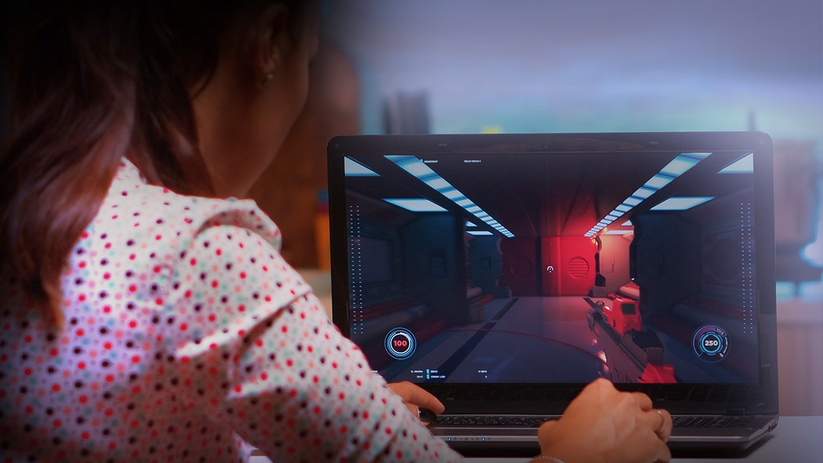 Woman playing video game on laptop