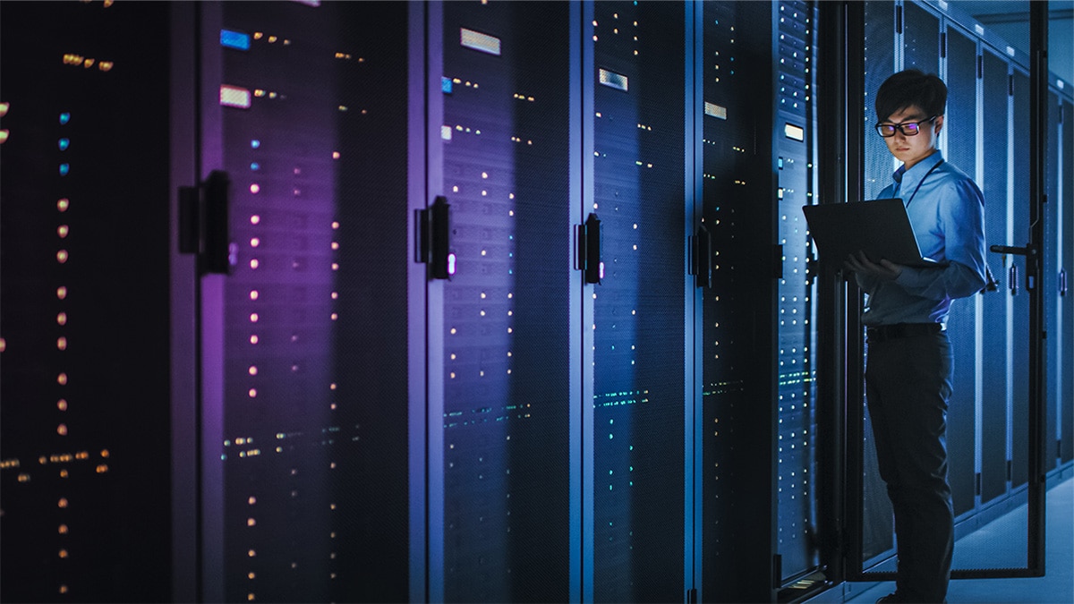 Man on laptop  in server room