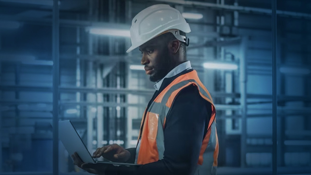 Man in hardhat using a laptop Man in hardhat using a laptop