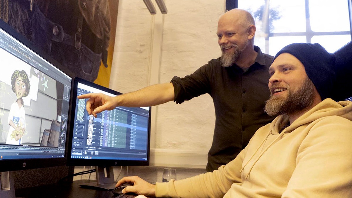 Coworkers at a computer working on a 3D modeling program