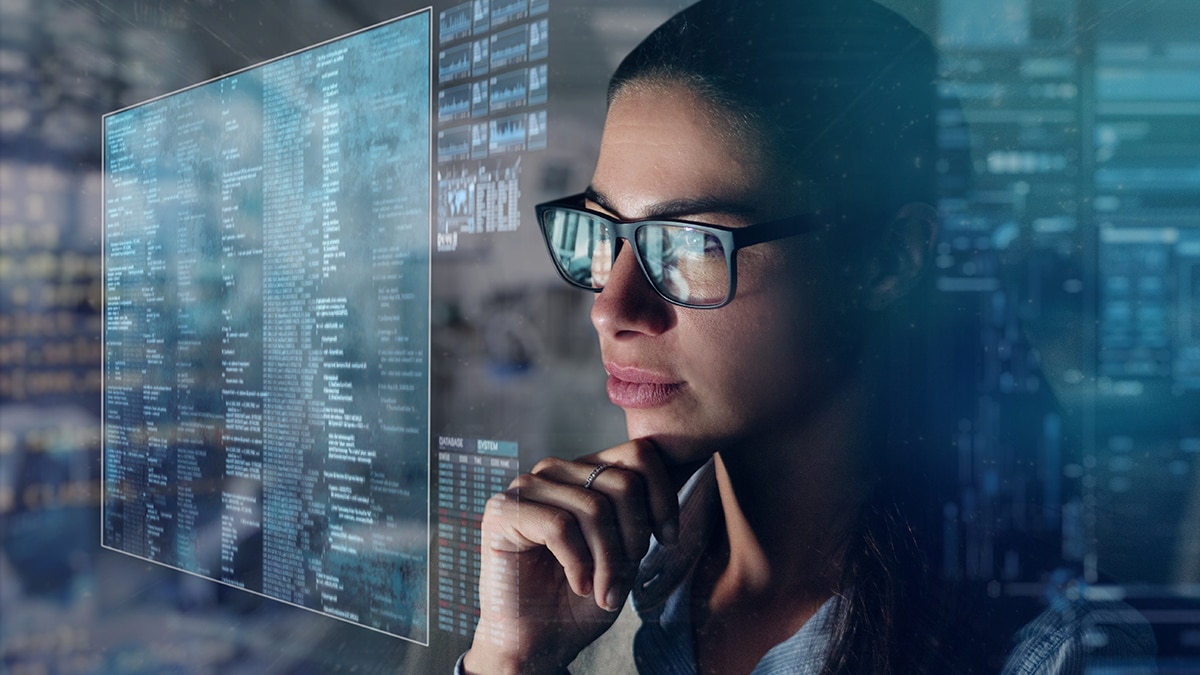 Close up of a beautiful girl with glasses while she is working with a futuristic computer with holograms. Concept: Future, technology, work