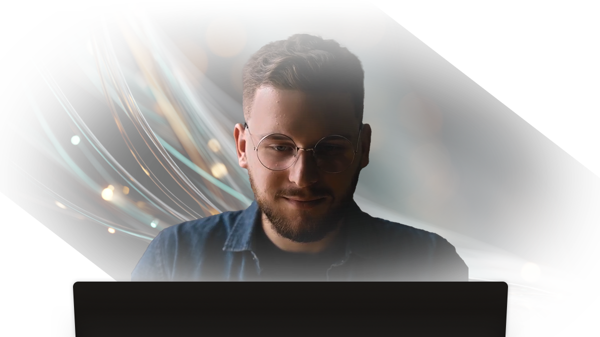 Man with glasses and beard looking downward, set against a dark background with glowing light trails and blurred bokeh effects.