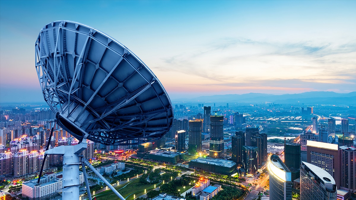 Satellite dish with cityscape in background