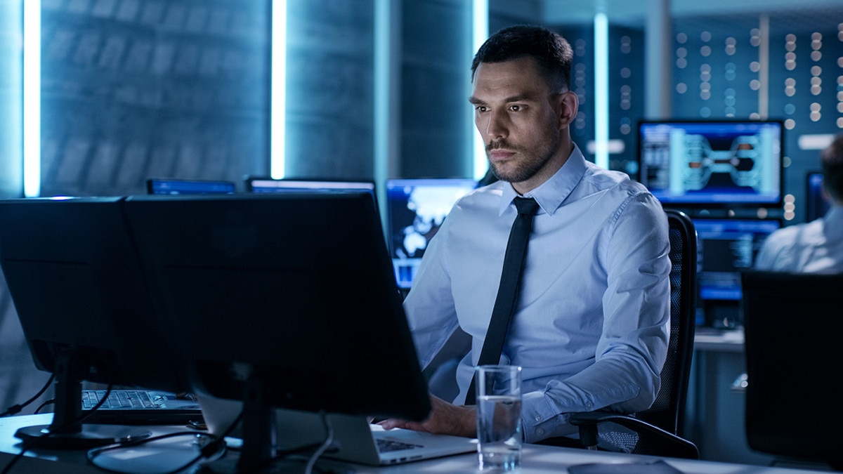 Man working on two screens in office