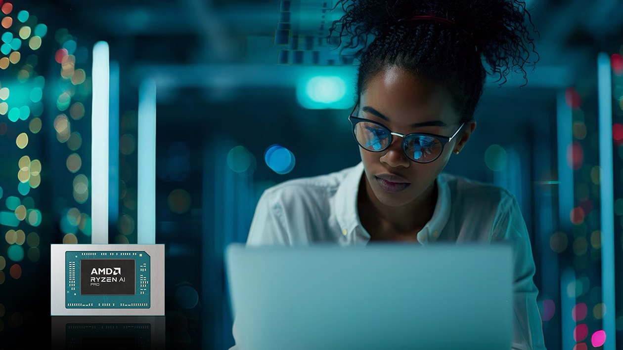 Woman working on laptop in server room. 