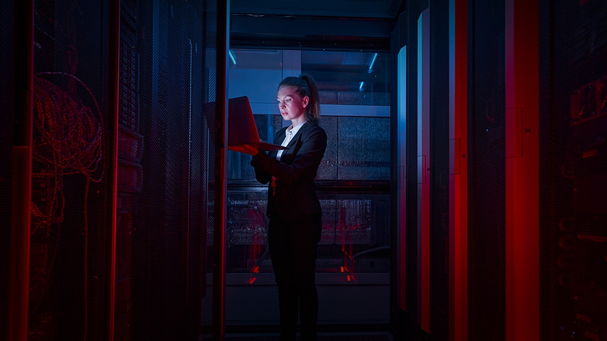 Woman working on laptop infront of servers