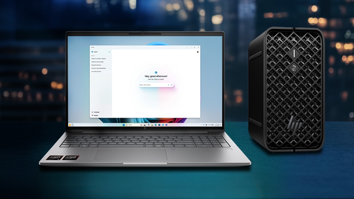 Laptop and desktop computers with AMD Ryzen on a desk, city skyline background